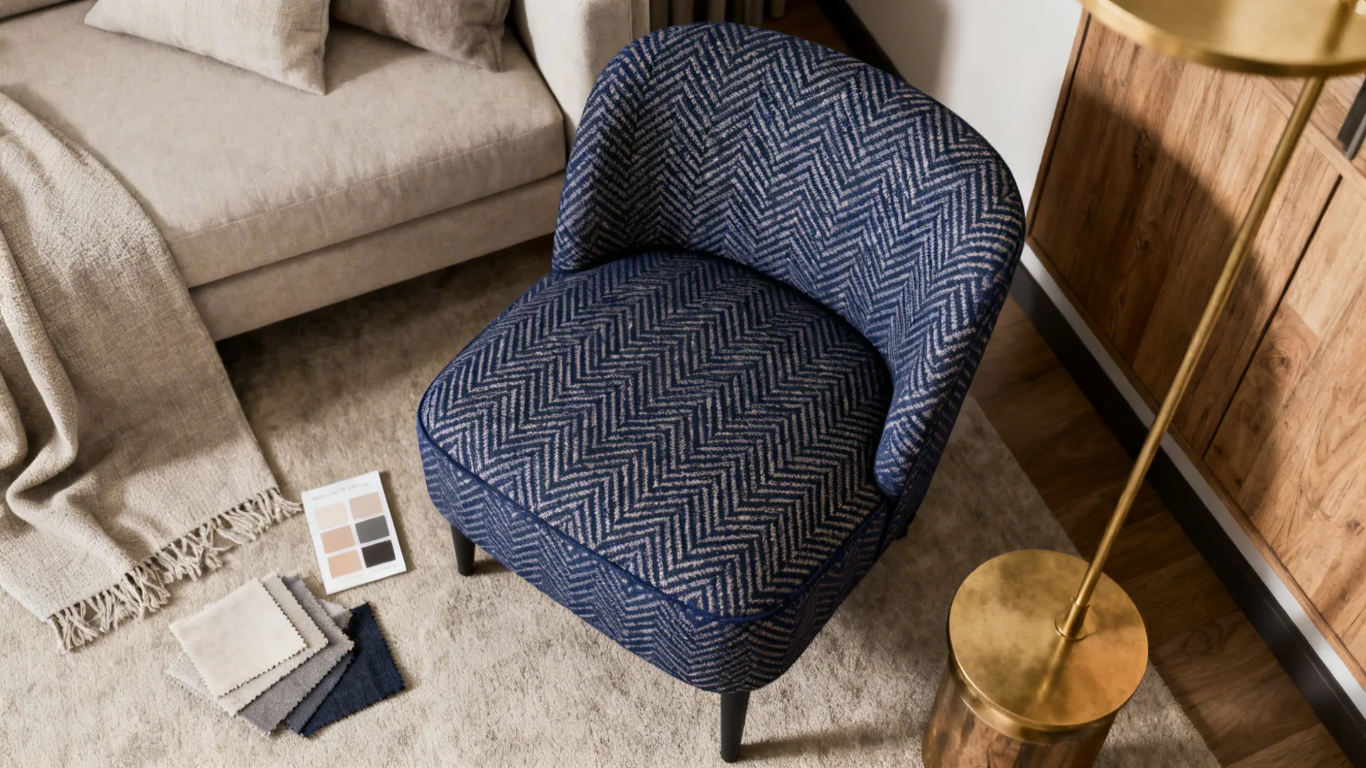 Patterned navy slipper chair with fabric swatches and neutral palette in a living room corner