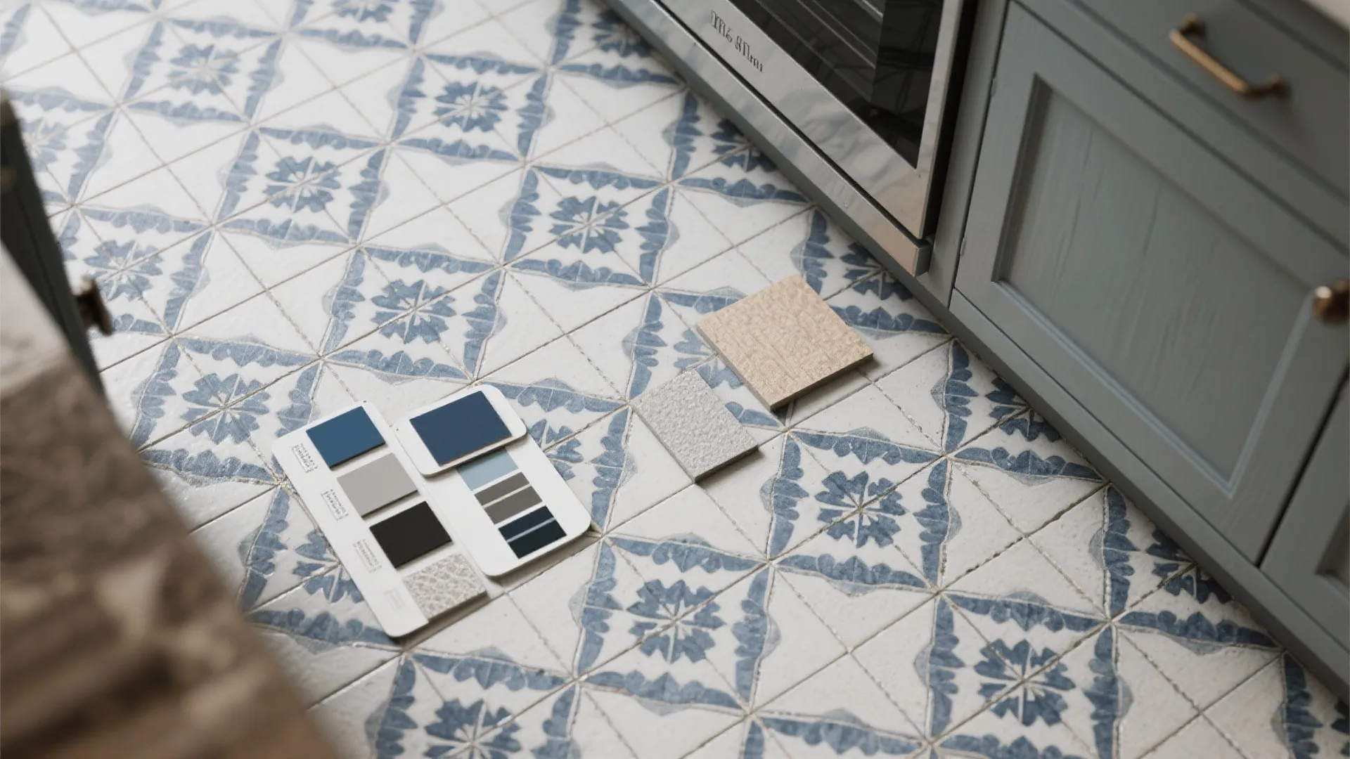 Flatlay of encaustic-style blue-gray tiles with cabinet and grout samples