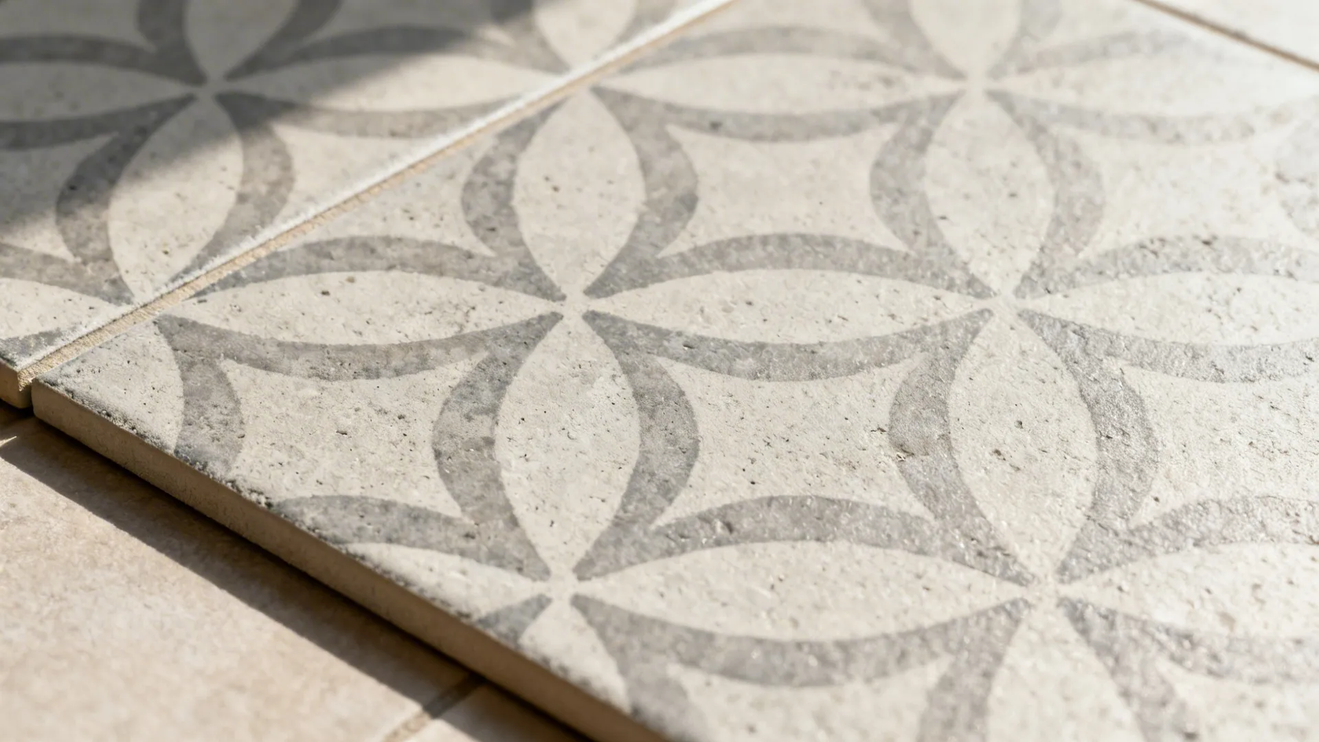 Macro of patterned cement-look porcelain with crisp print and clean grout under soft daylight.