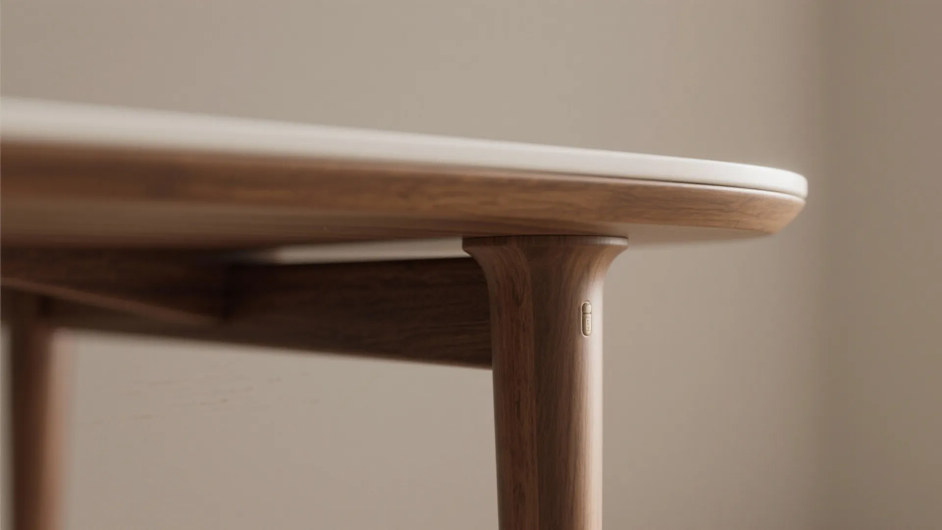Macro detail of a slim pedestal table corner with rounded edges and visible joinery and wood grain.