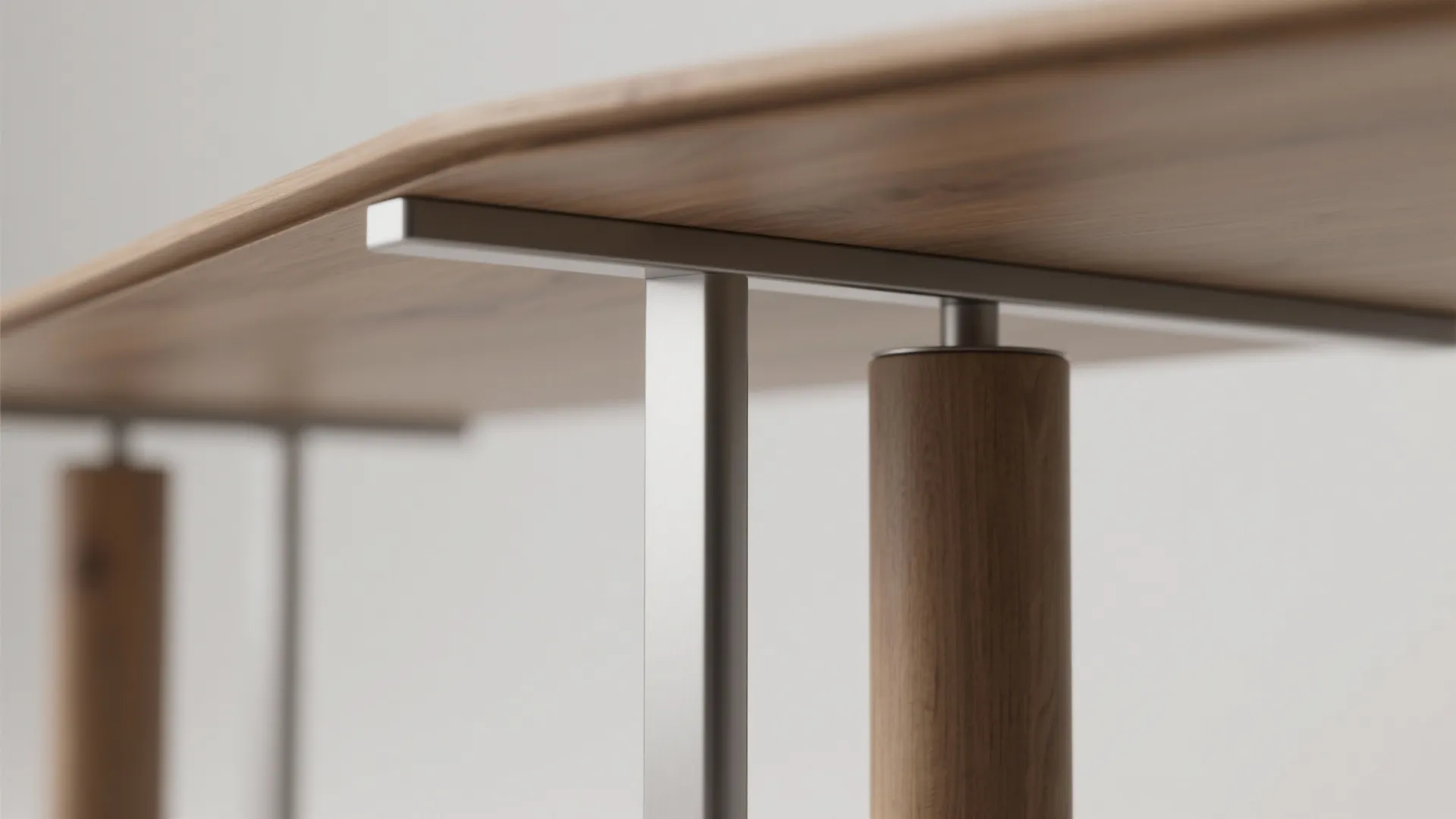 Macro detail of a narrow rectangular table's cantilevered metal base and slim pedestal joinery on a light oak top.