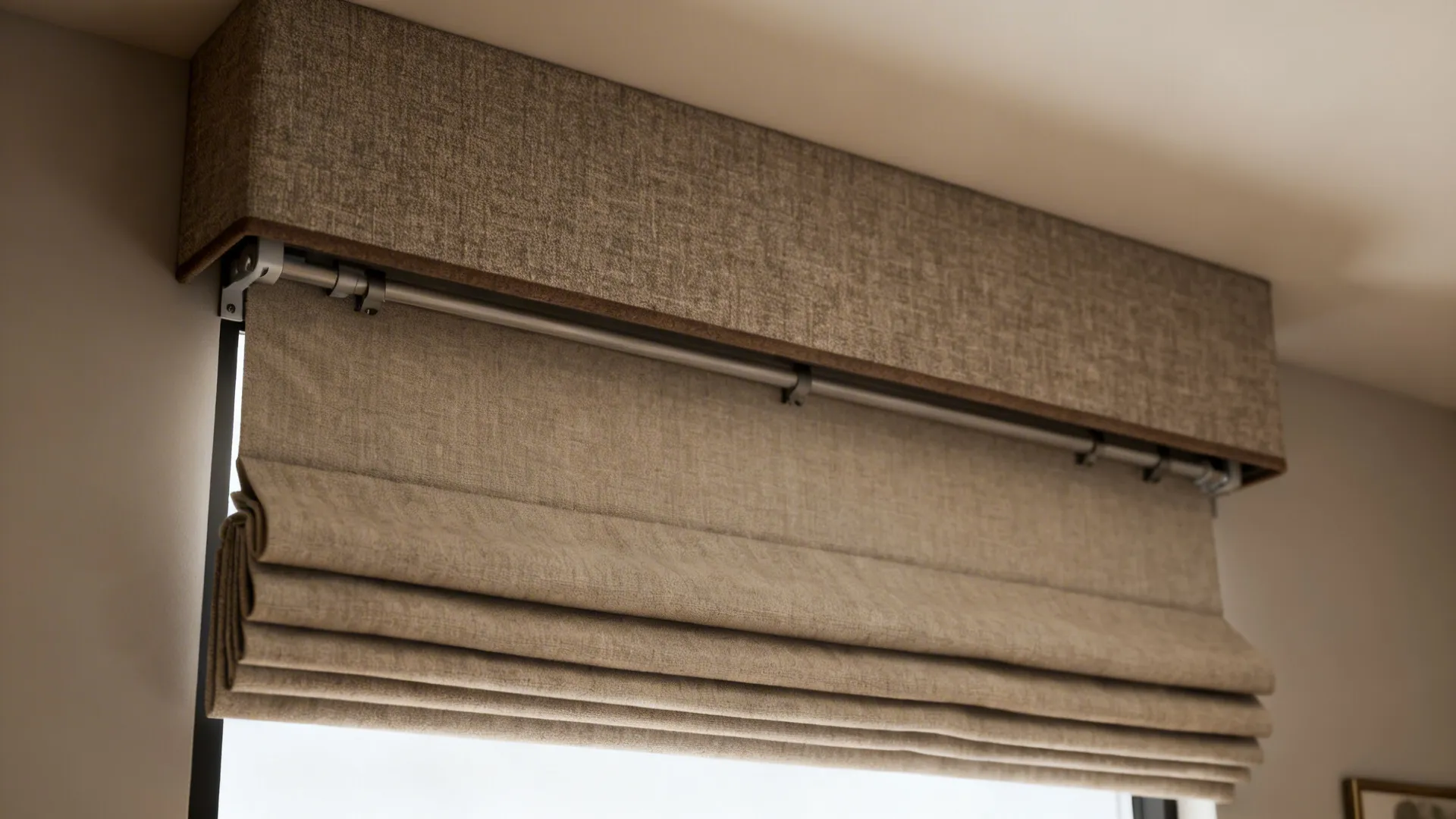 Light brown fabric curtain top covering a matching folded window blind on a white wall