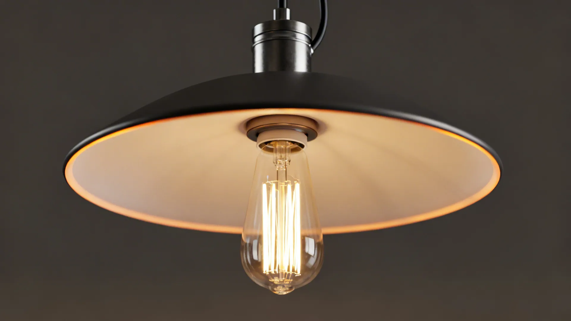 Macro detail of a pendant shade edge, LED filament and metal canopy showing build quality and glare control.