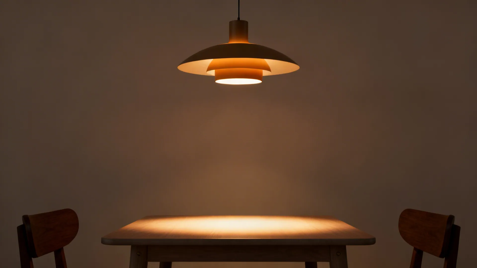 Pendant light centered over a small dining table creating a defined dining zone