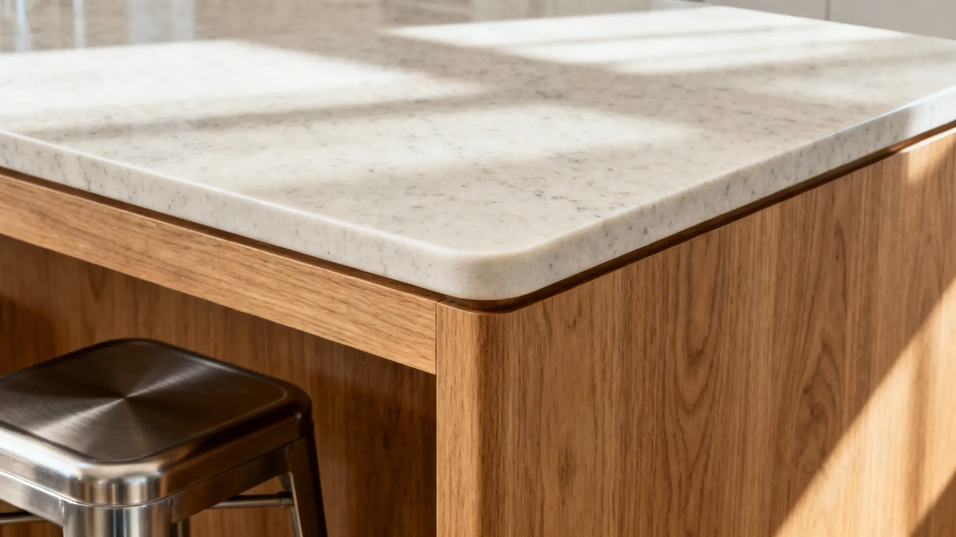 Close-up of quartz edge and oak peninsula overhang with soft matte finishes.