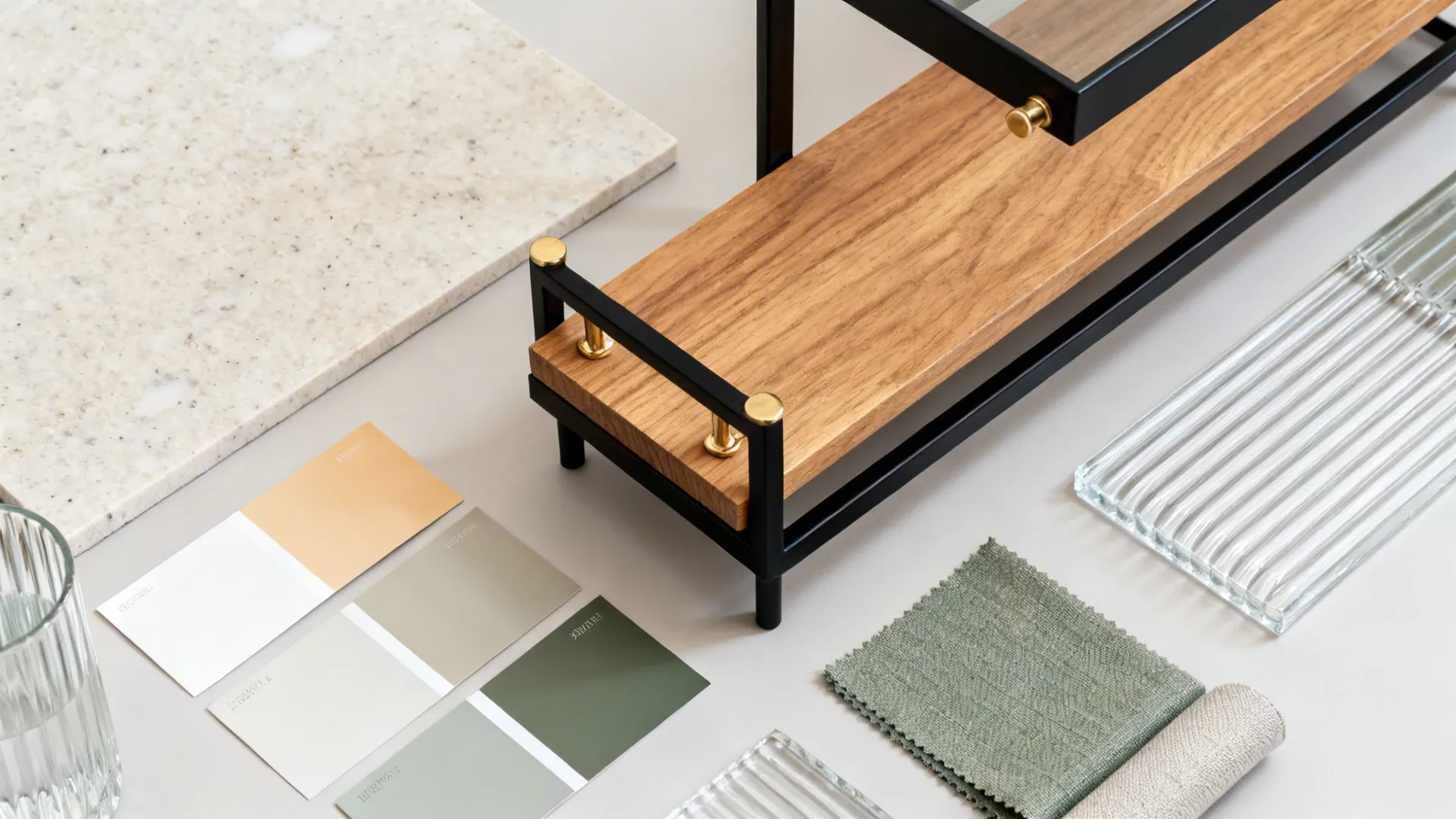 Top-down materials board with light stone, oak, matte black metal, and neutral paints.
