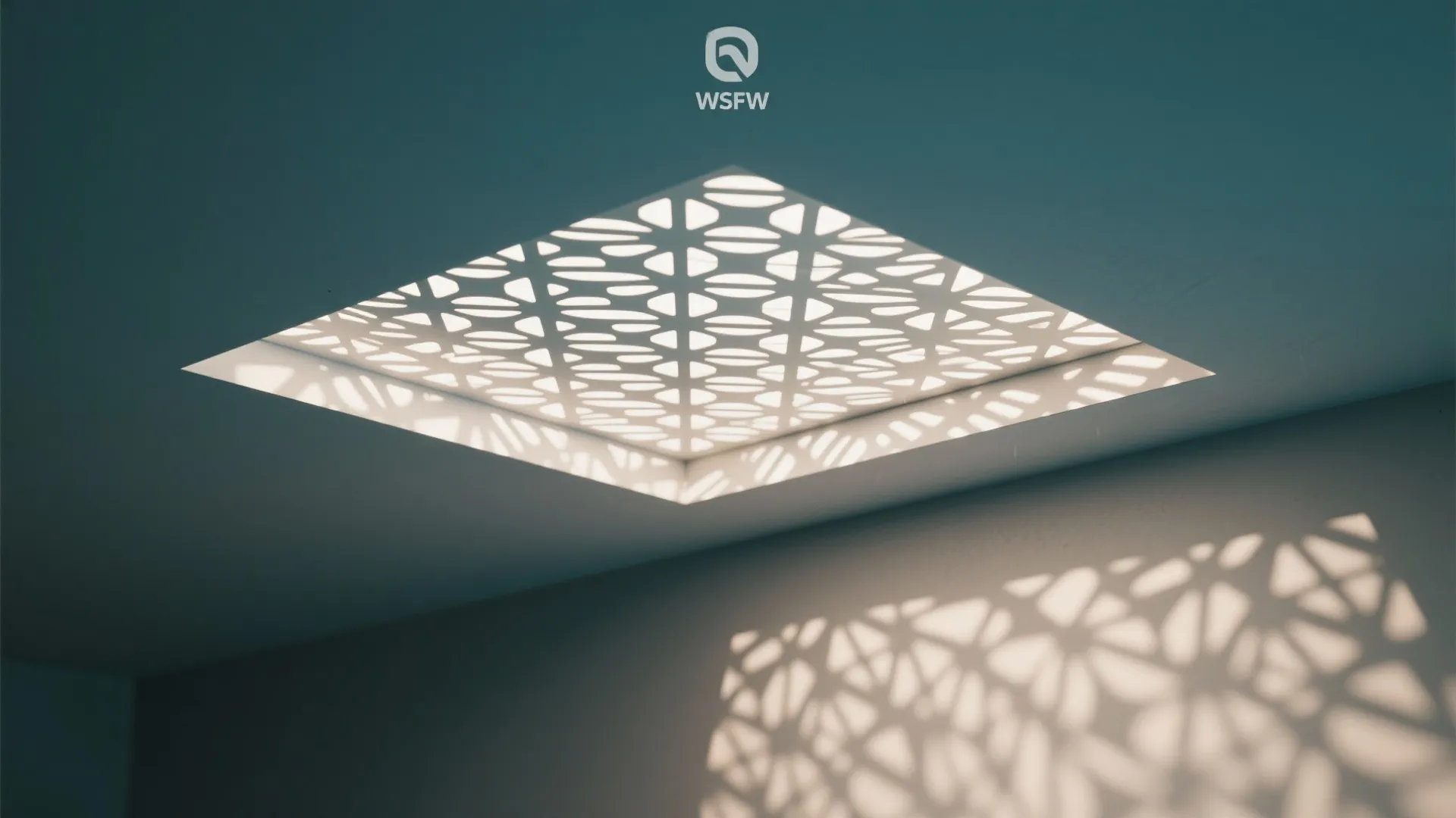 Square ceiling light with patterned cover creating artistic shadows on a white wall in interior