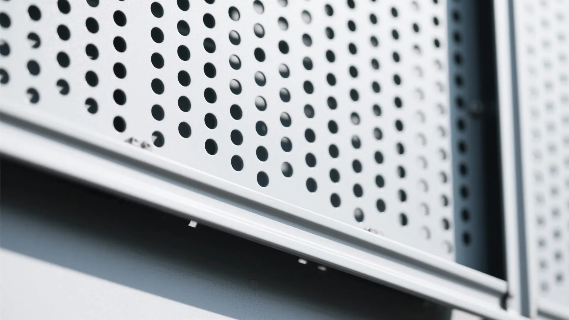 Close-up of circular perforated aluminum with powder-coat finish and framed edge.