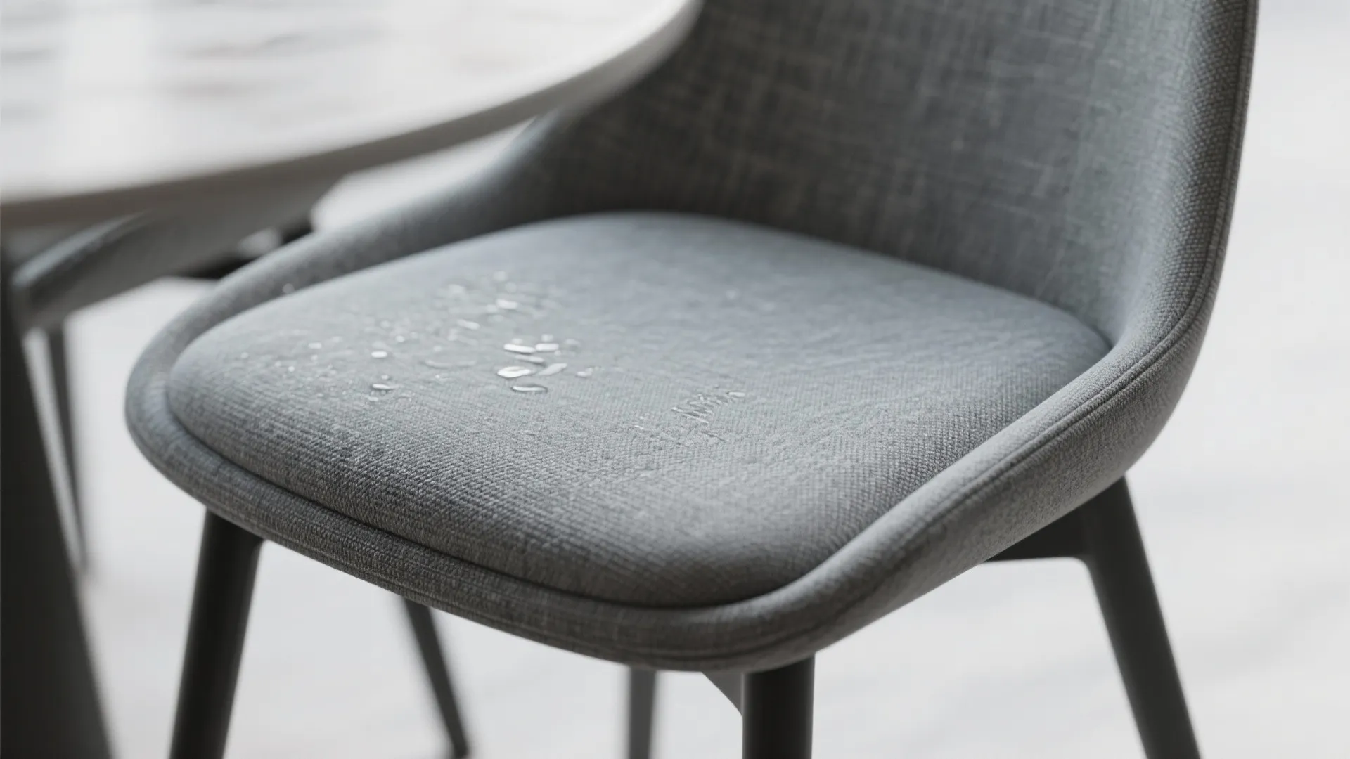 Close up of water droplets on a grey fabric chair showing waterproof performance in kitchen