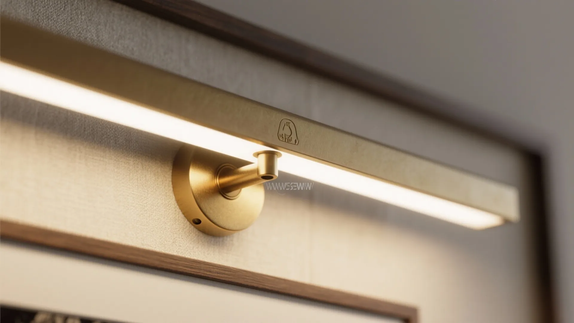 Macro of matte brass picture light illuminating textured framed fabric art.