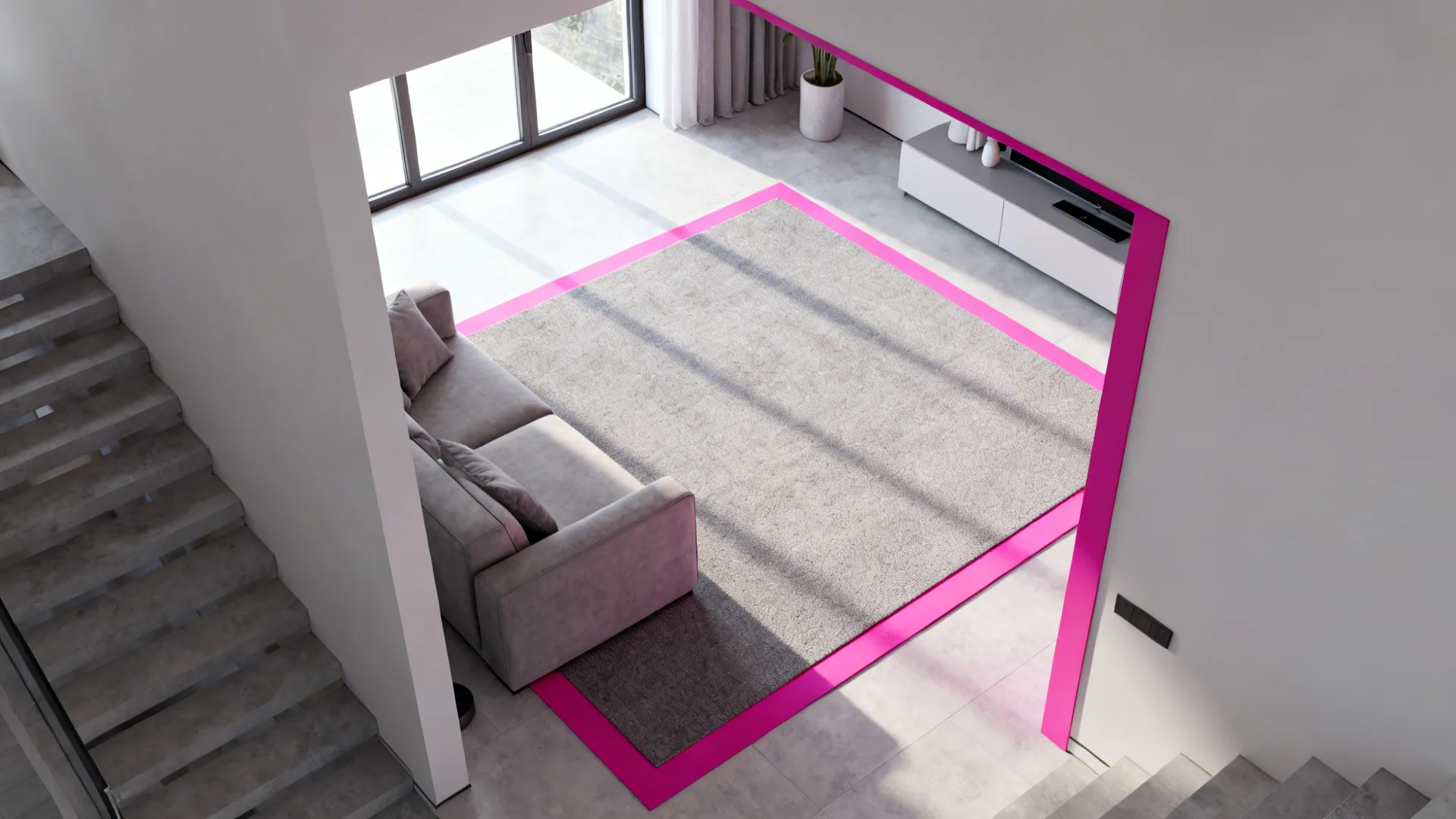 Open-plan studio with a neutral grey rug framed by a crisp pink border defining the seating area