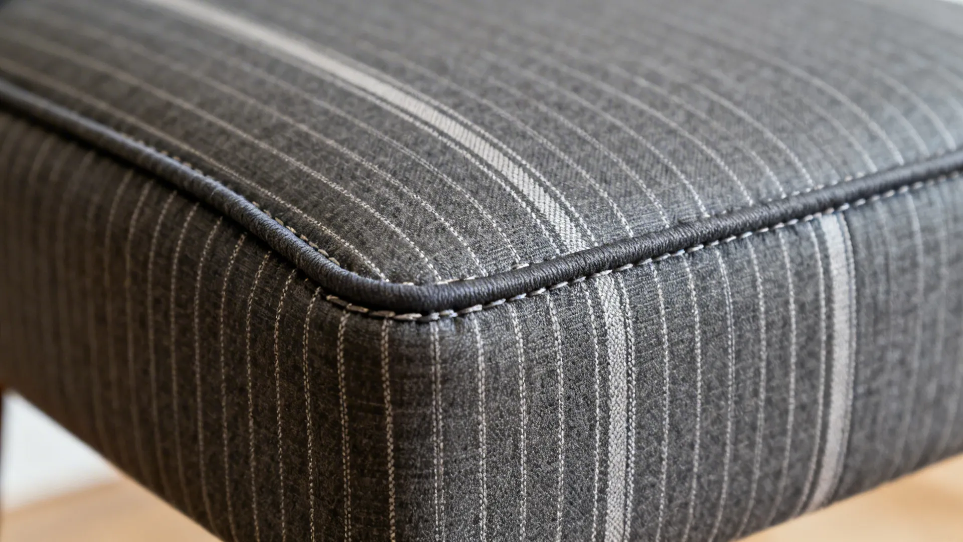 Close-up of a charcoal pinstripe seat cover with centered stripe and crisp piping on a dining chair.