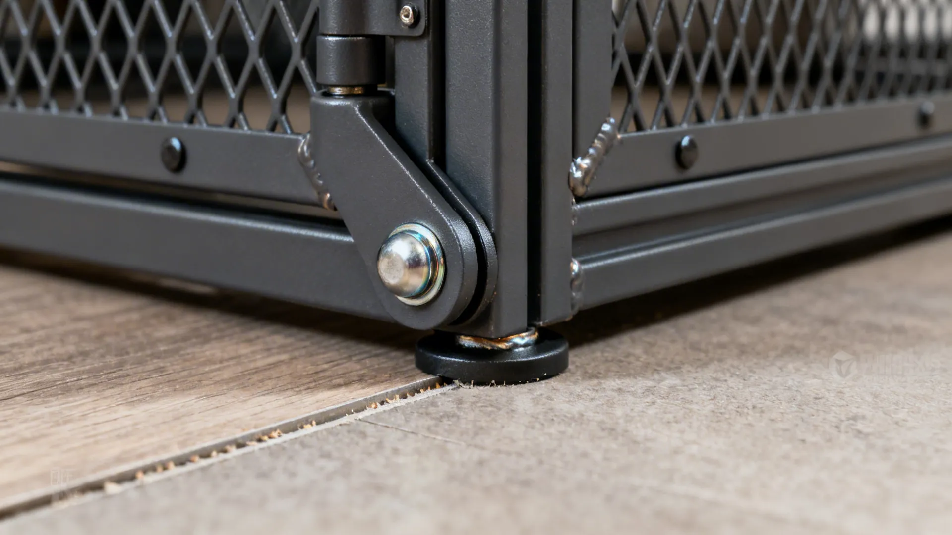 Macro of a ball-bearing pivot hinge on a powder-coated steel lattice gate.