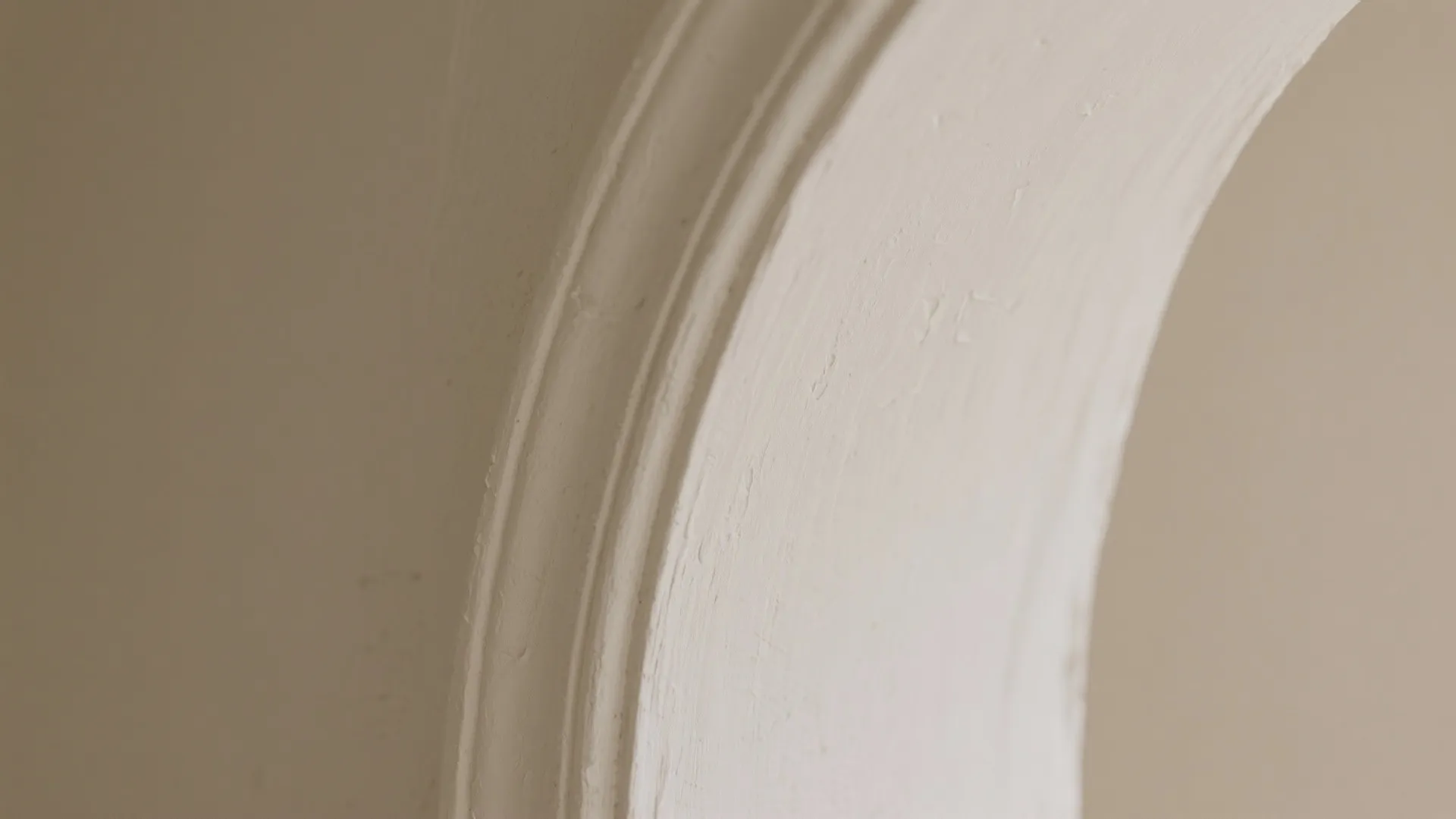 Close up view of a white wall panel with curved edges showing clean interior design details