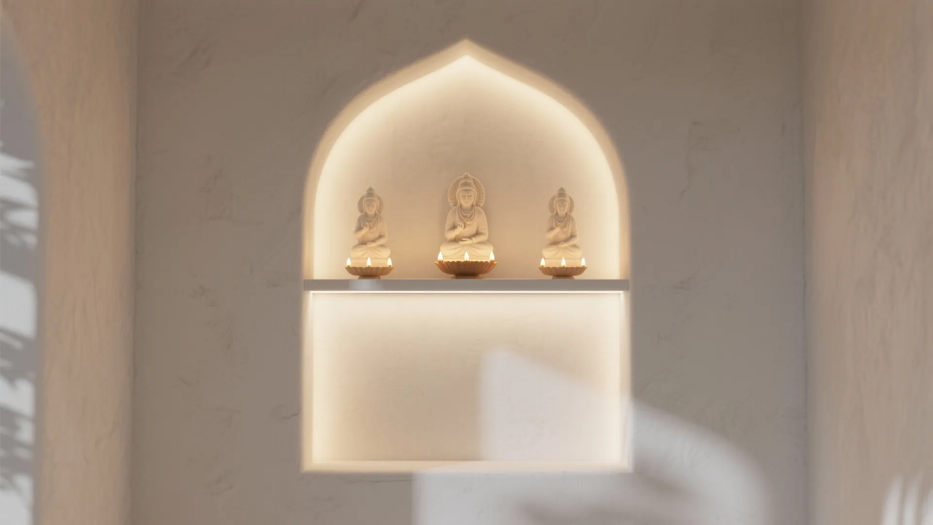 Modern white arched wall niche with warm light and three small white statues on shelf