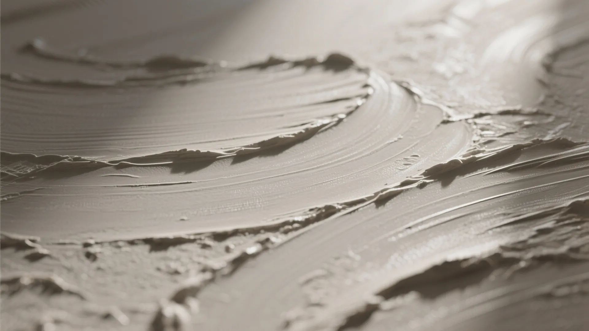 Close up view of thick textured white plaster paint with light and shadow on a wall