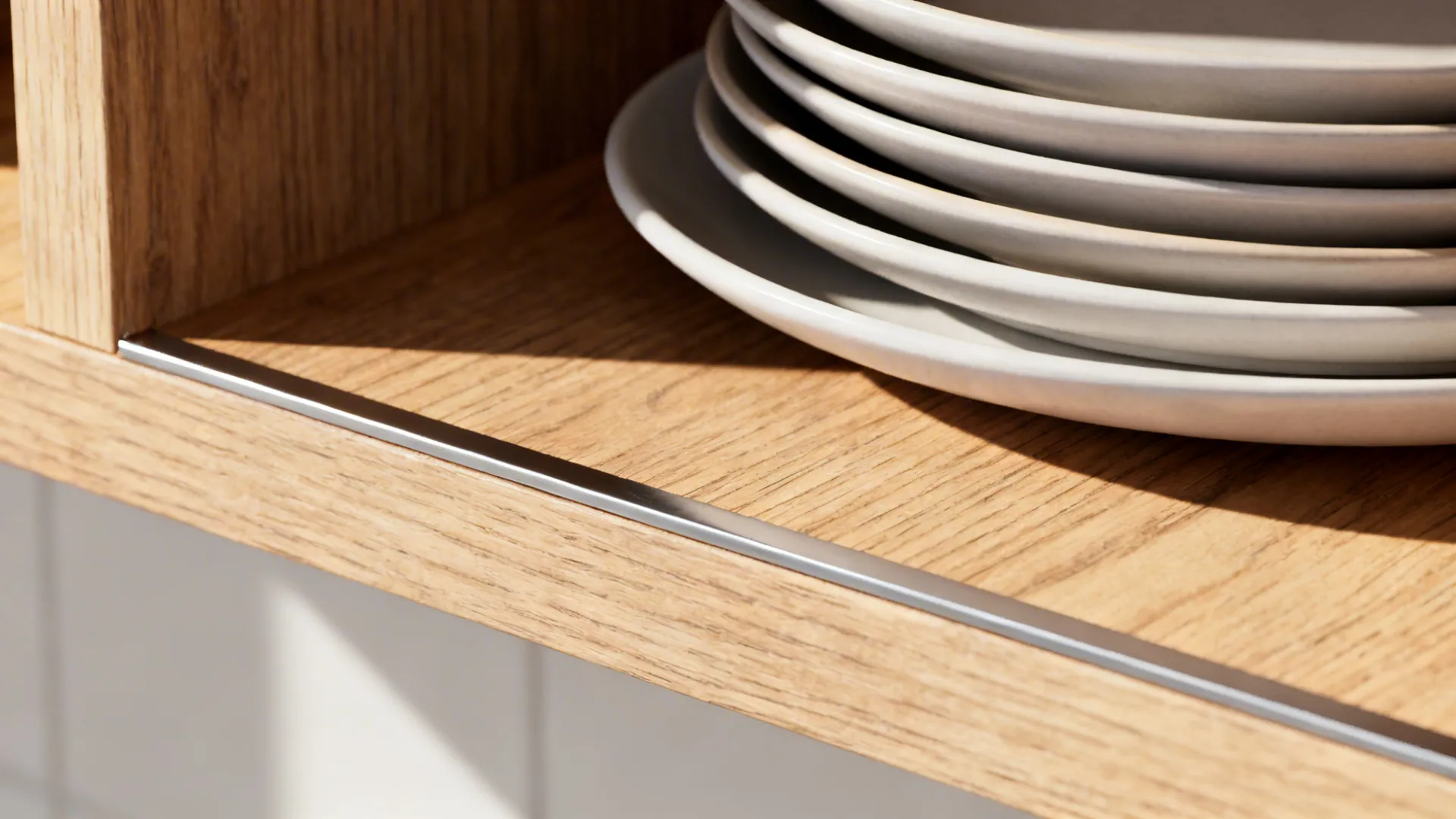 Macro of a reinforced 18 mm shelf with a plate ledge lip supporting matte porcelain plates.