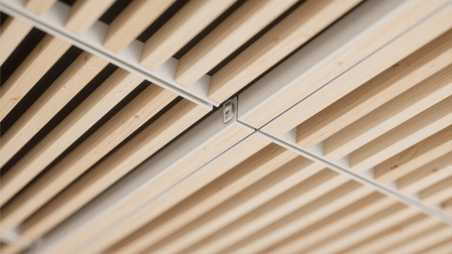 Close up view of a modern ceiling design featuring light wood panels and white metal frames