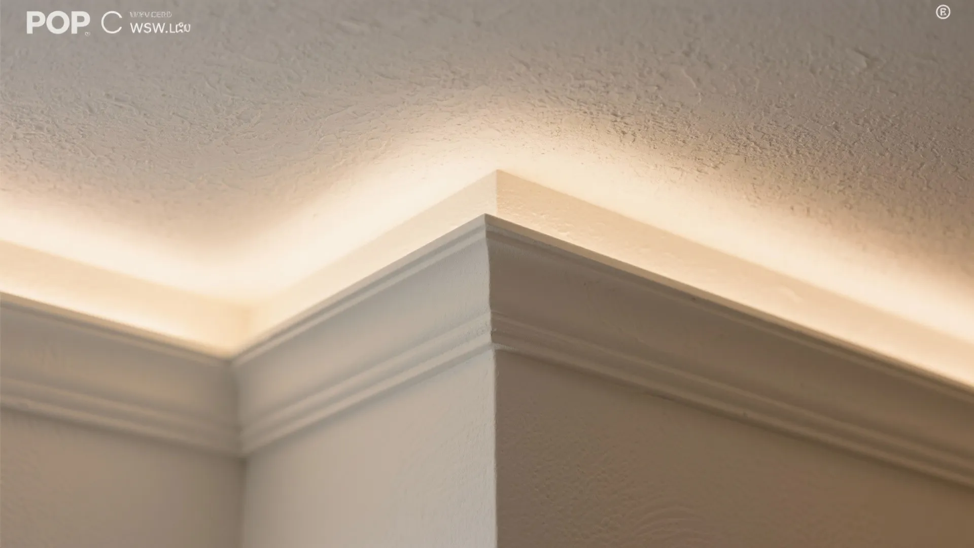 Close up view of white wall panel detail with warm hidden light strip on ceiling