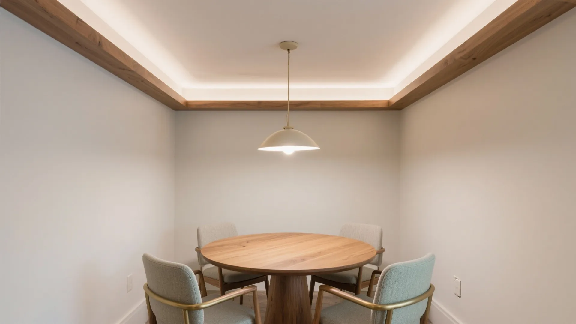 Small dining space with a round wooden table, four chairs, and a hanging light fixture