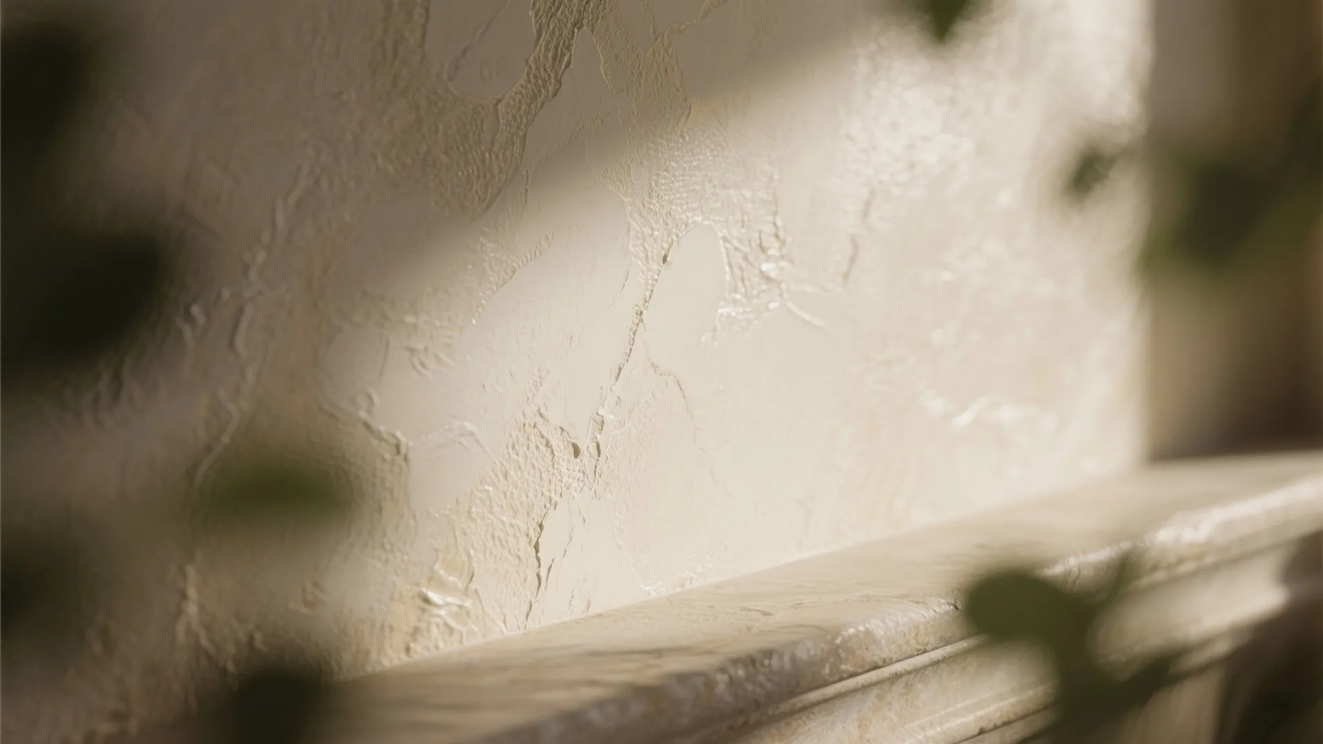 Close up view of textured cream wall panel with natural sunlight and marble stone shelf