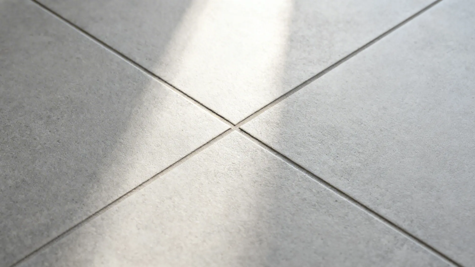 Top-down macro of matte porcelain floor with tight color-matched grout.