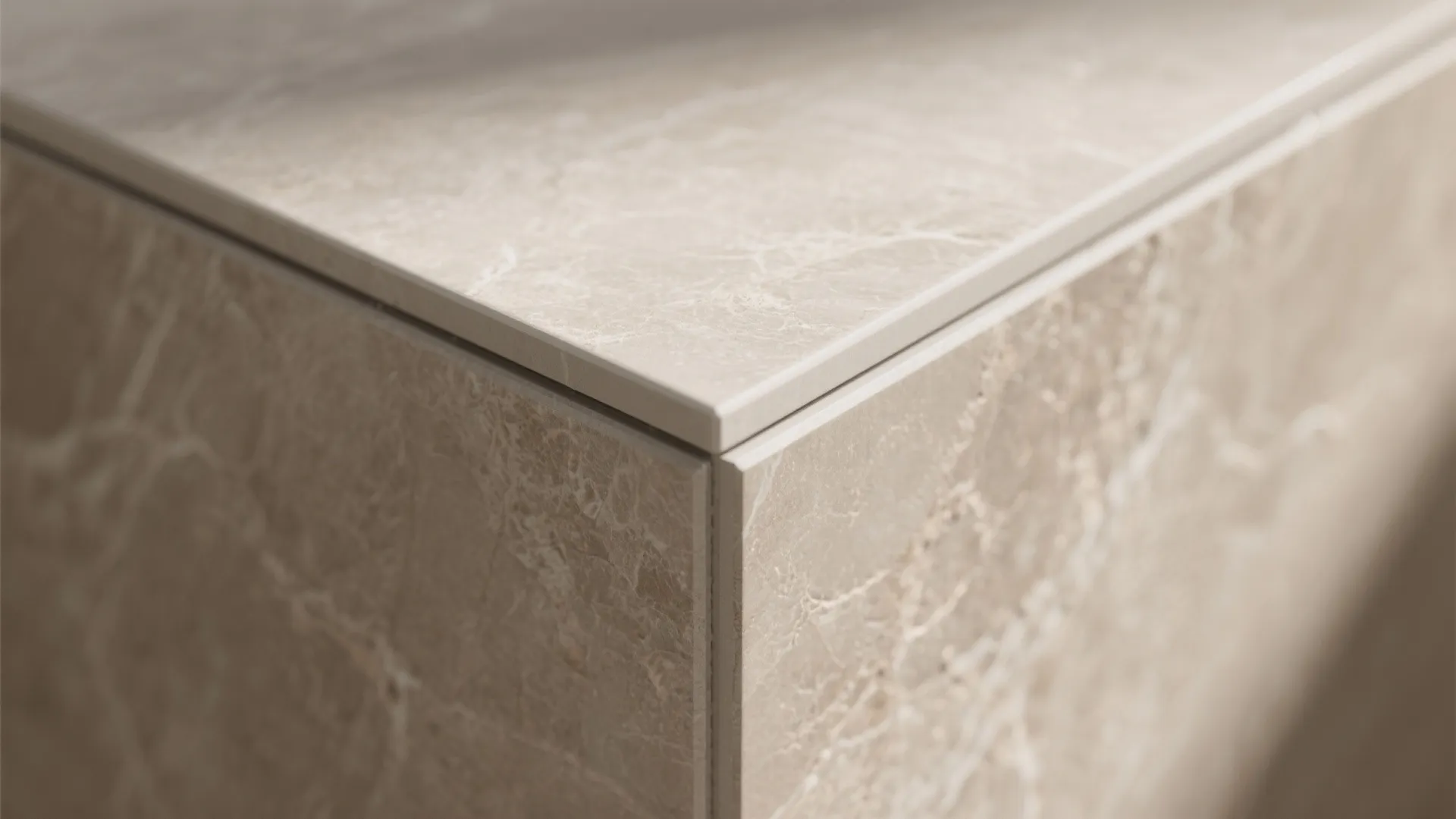 Close up of beige marble kitchen counter edge showing clean grout lines and smooth stone surface