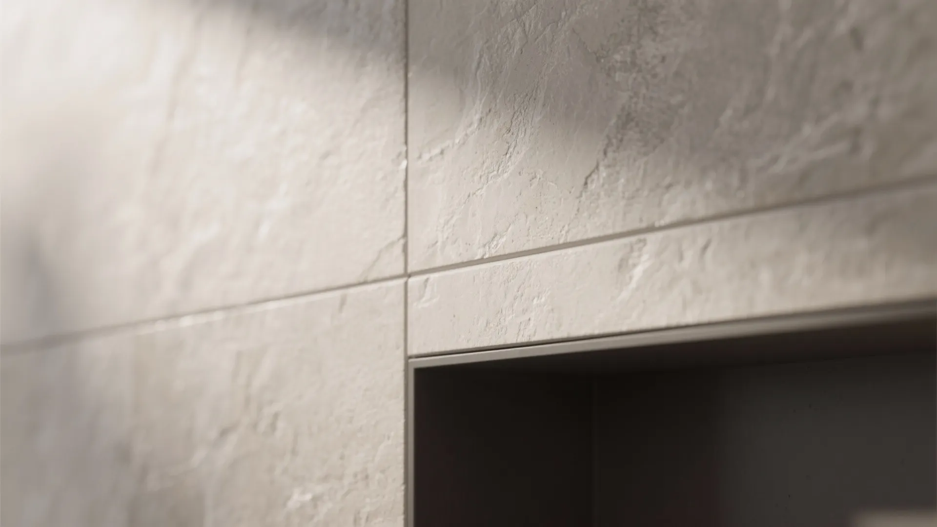 Close up of textured stone wall tiles with clean grout lines and a dark shelf niche