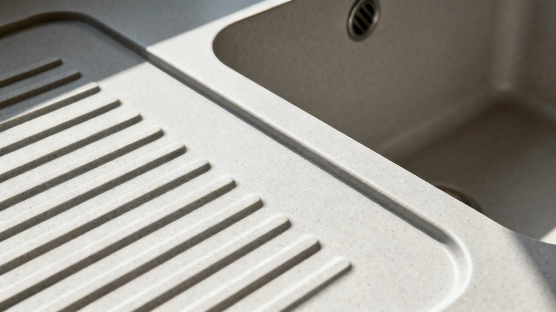 Macro view of pale gray sintered stone with drainboard flutes and 12 mm edge.