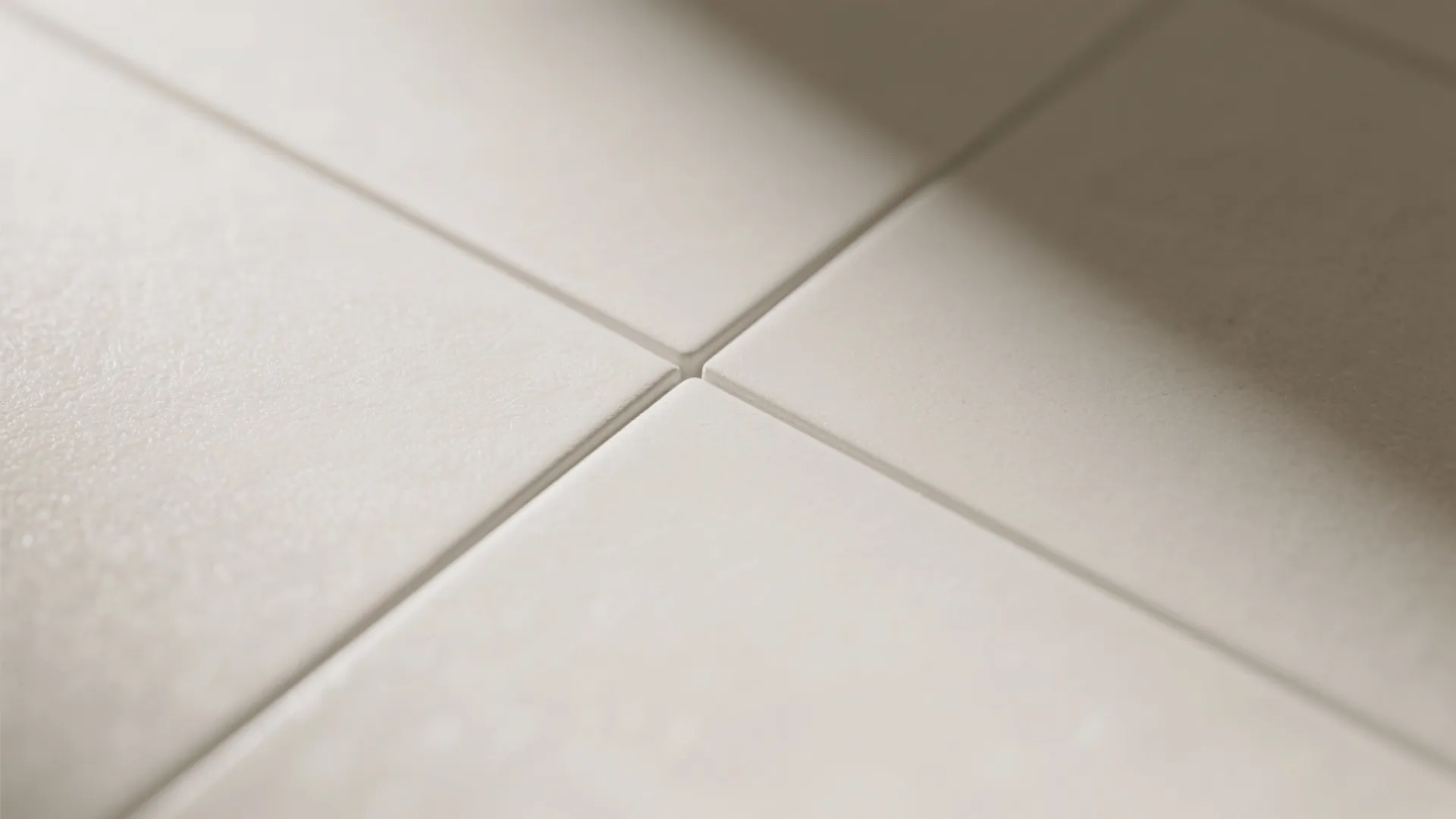 Close up view of clean white square bathroom tiles with smooth texture and thin grout lines