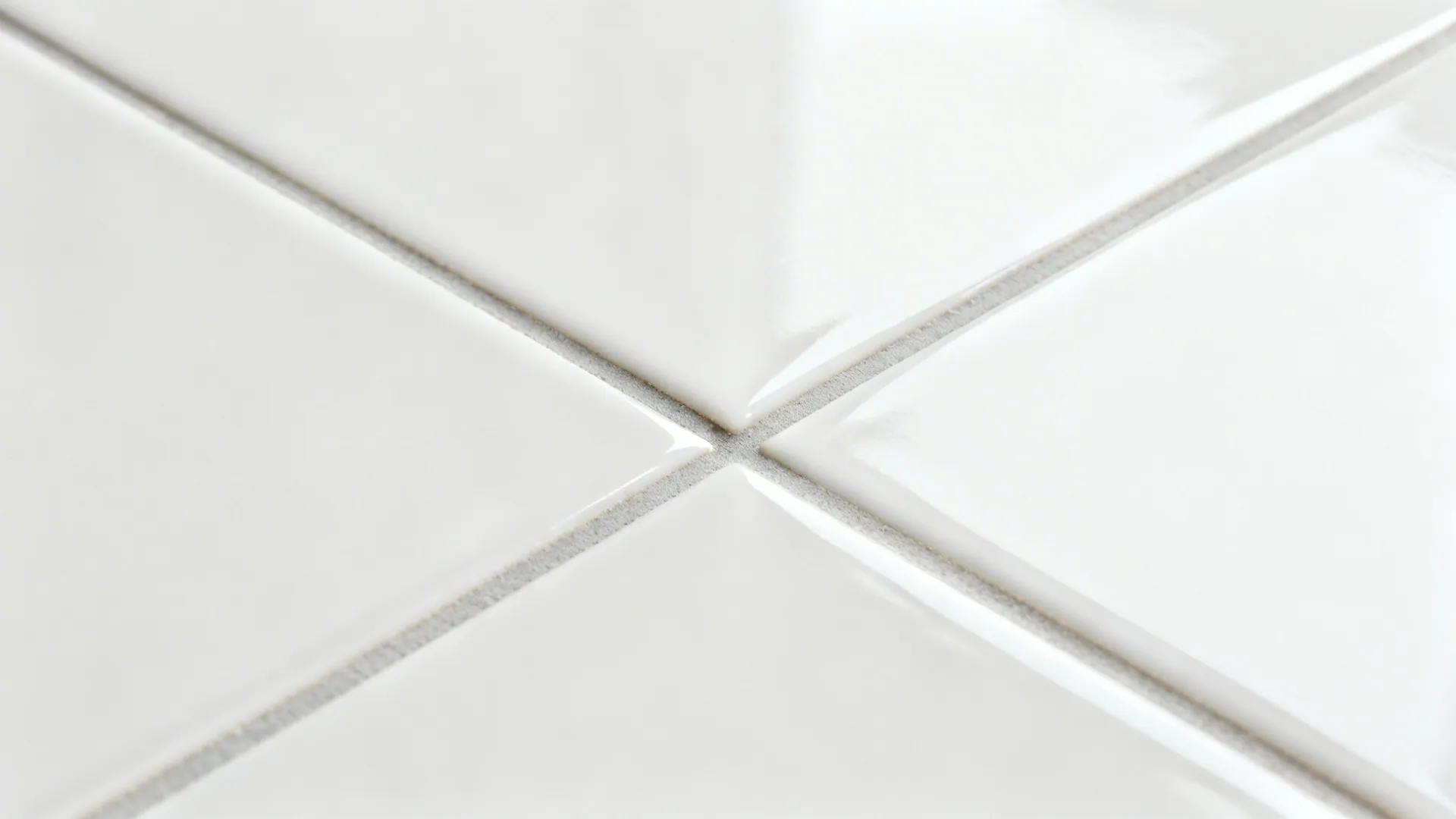 Macro view of rectified polished porcelain tile with tight gray grout.