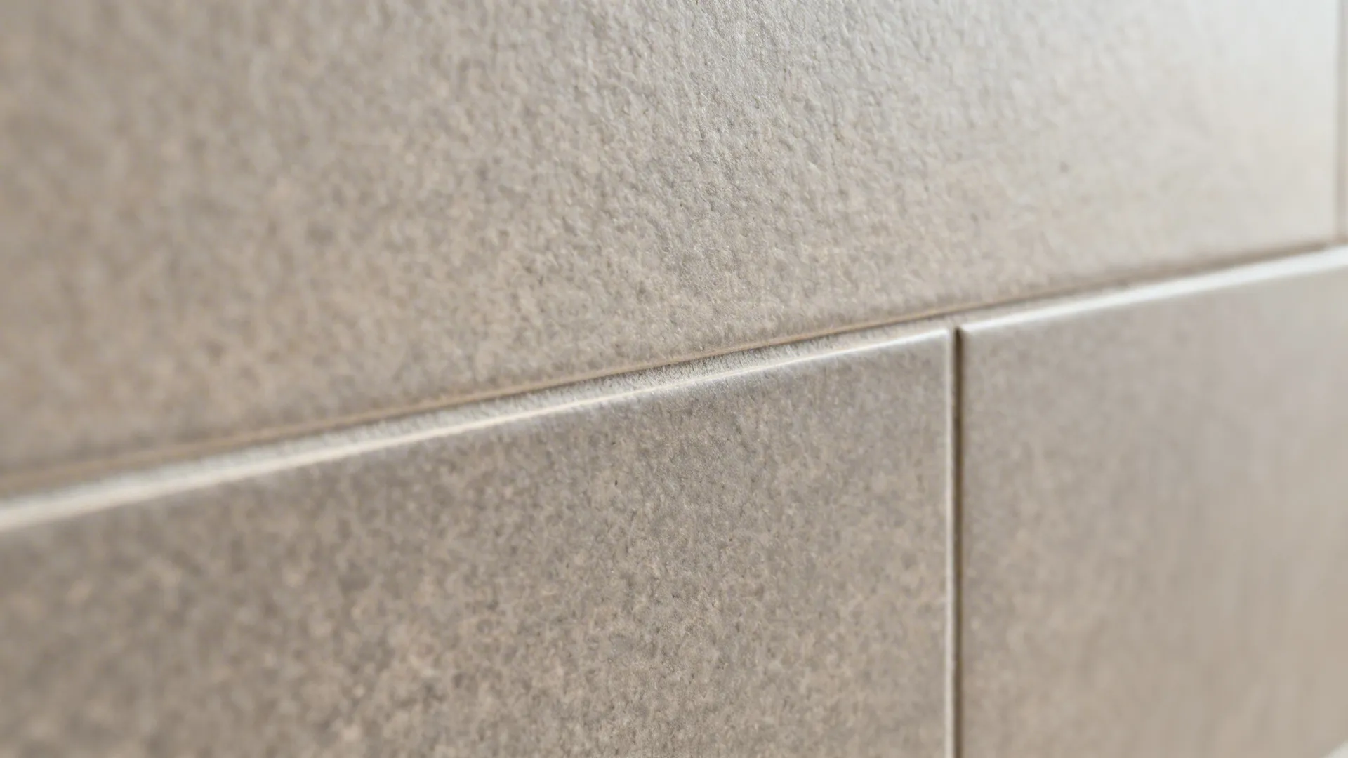 Macro of matte porcelain slab backsplash showing rectified edge and tight grout line.