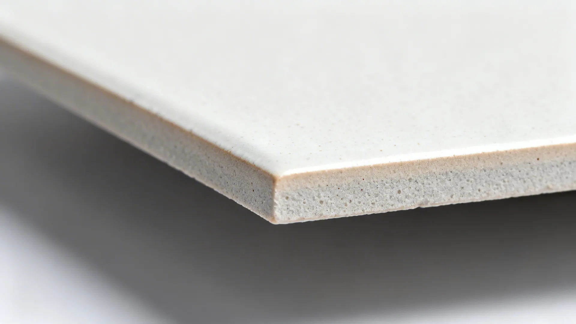 Macro of porcelain tile edge and surface showing dense, refined finish and rectified edge.