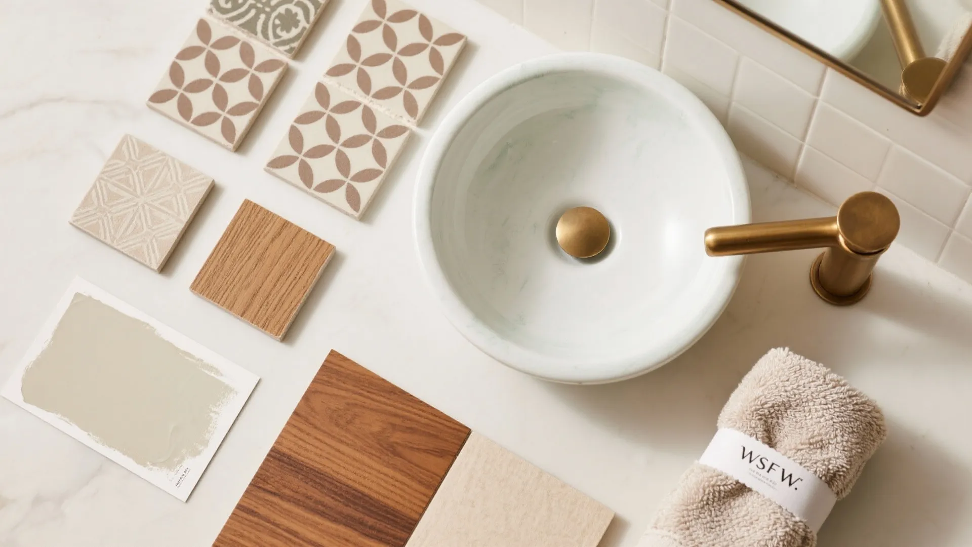 Flatlay of ceramic, limewash, patterned tiles, brushed brass, and warm wood for a statement powder room.
