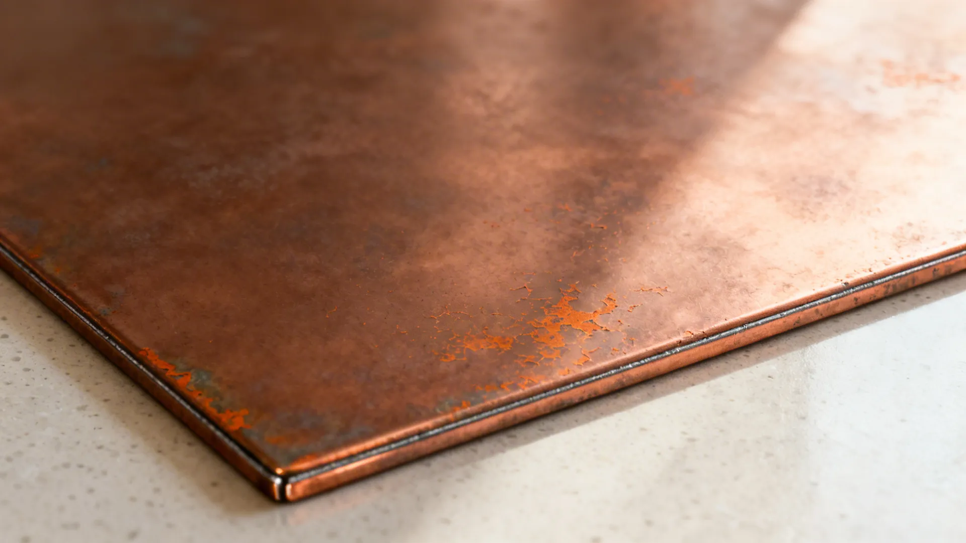 Macro of matte clear-coated pre-aged copper panel with clean seam detail.