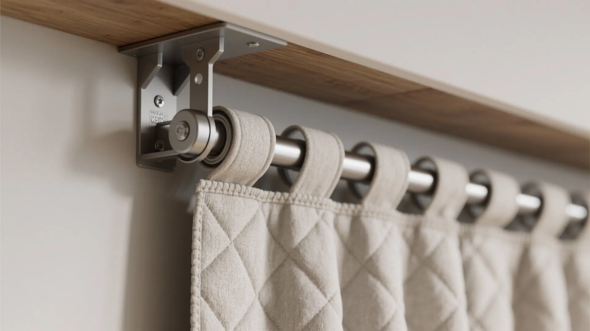Close up of a metal curtain rod attached to a wooden shelf with quilted fabric hanging