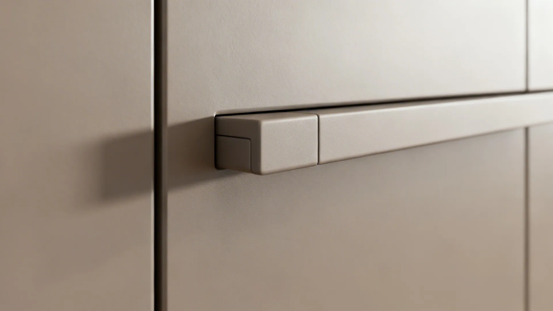 Macro detail of a warm gray push-latch cabinet door with a clean shadow gap.