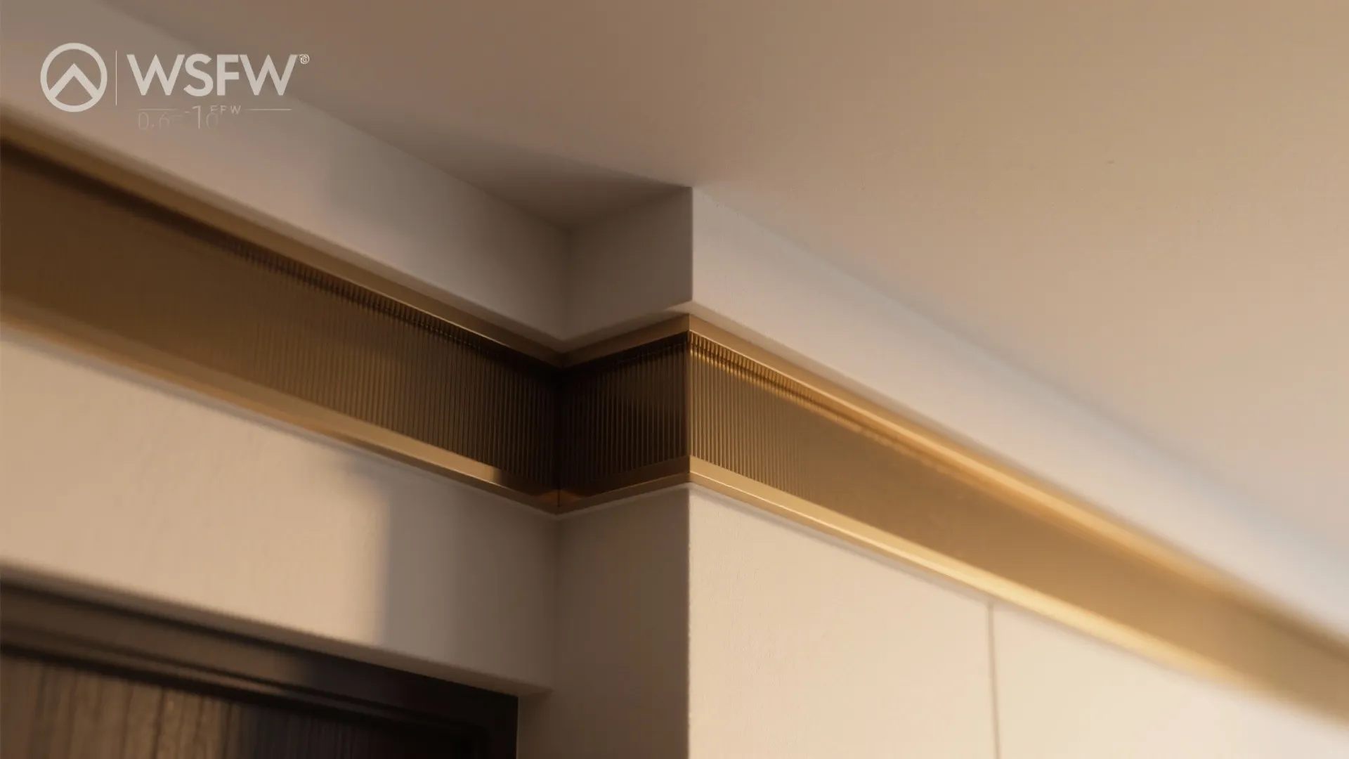 Close up of a wall corner featuring a decorative metal trim piece and white wall panel
