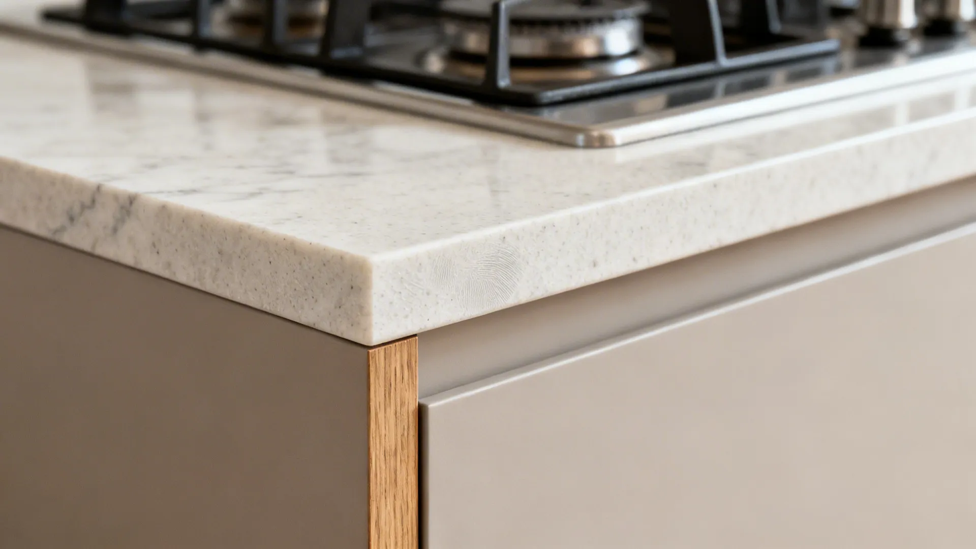 Macro of light quartz edge and matte cabinet texture with a warm wood panel detail.