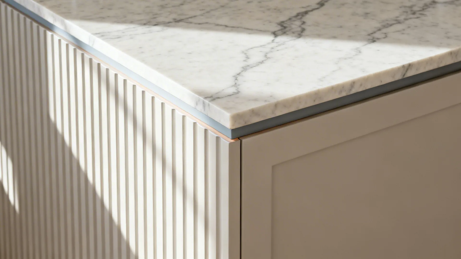 Close-up of marble-look quartz meeting a satin-painted fluted panel with an eased edge.