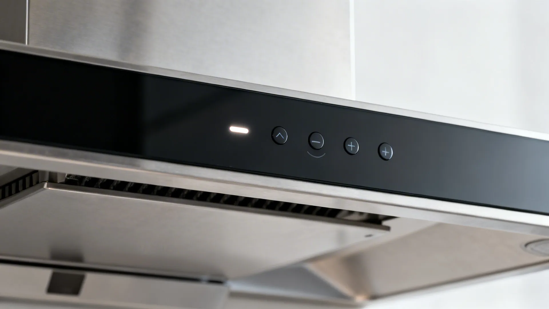 Macro detail of a quiet range hood’s minimalist control panel with soft LED indicator.