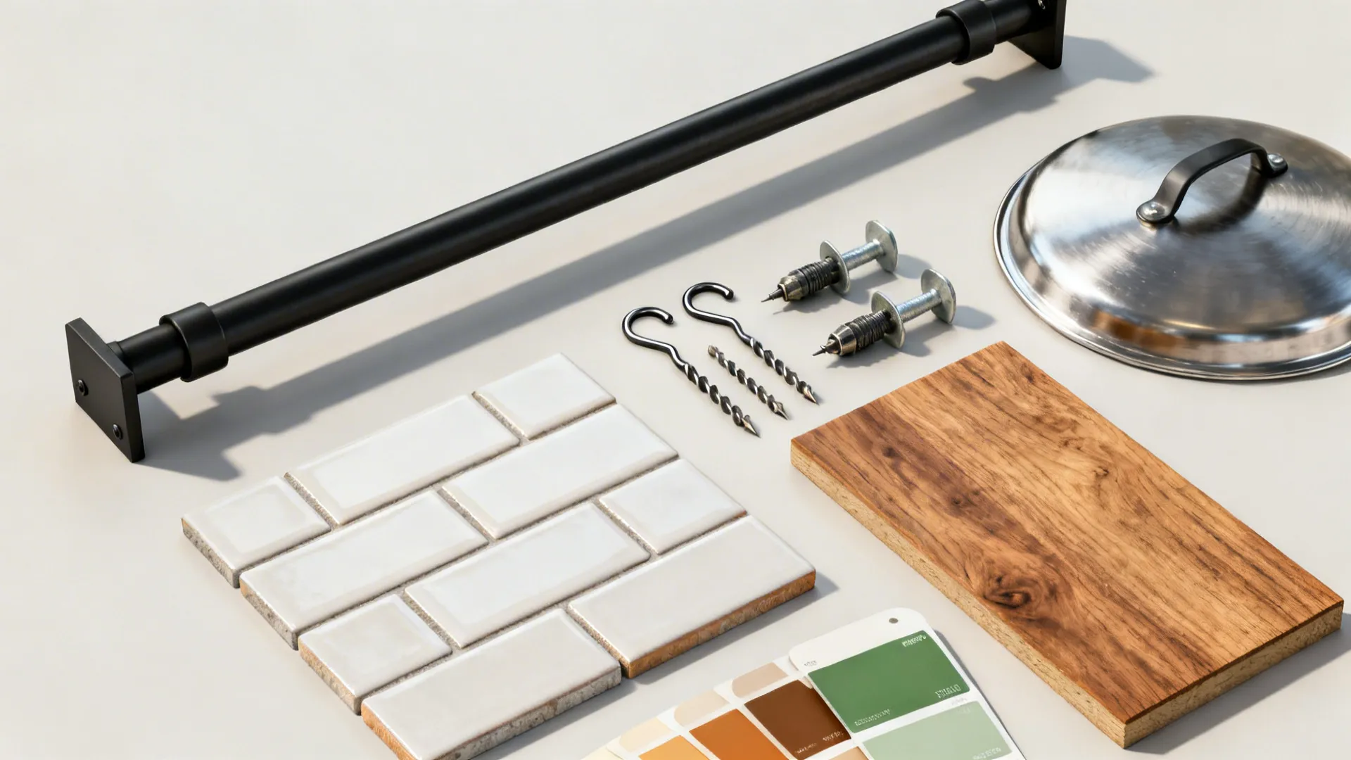 Top-down arrangement of a matte black rail, hooks, drill bits, tile, and warm neutral swatches.