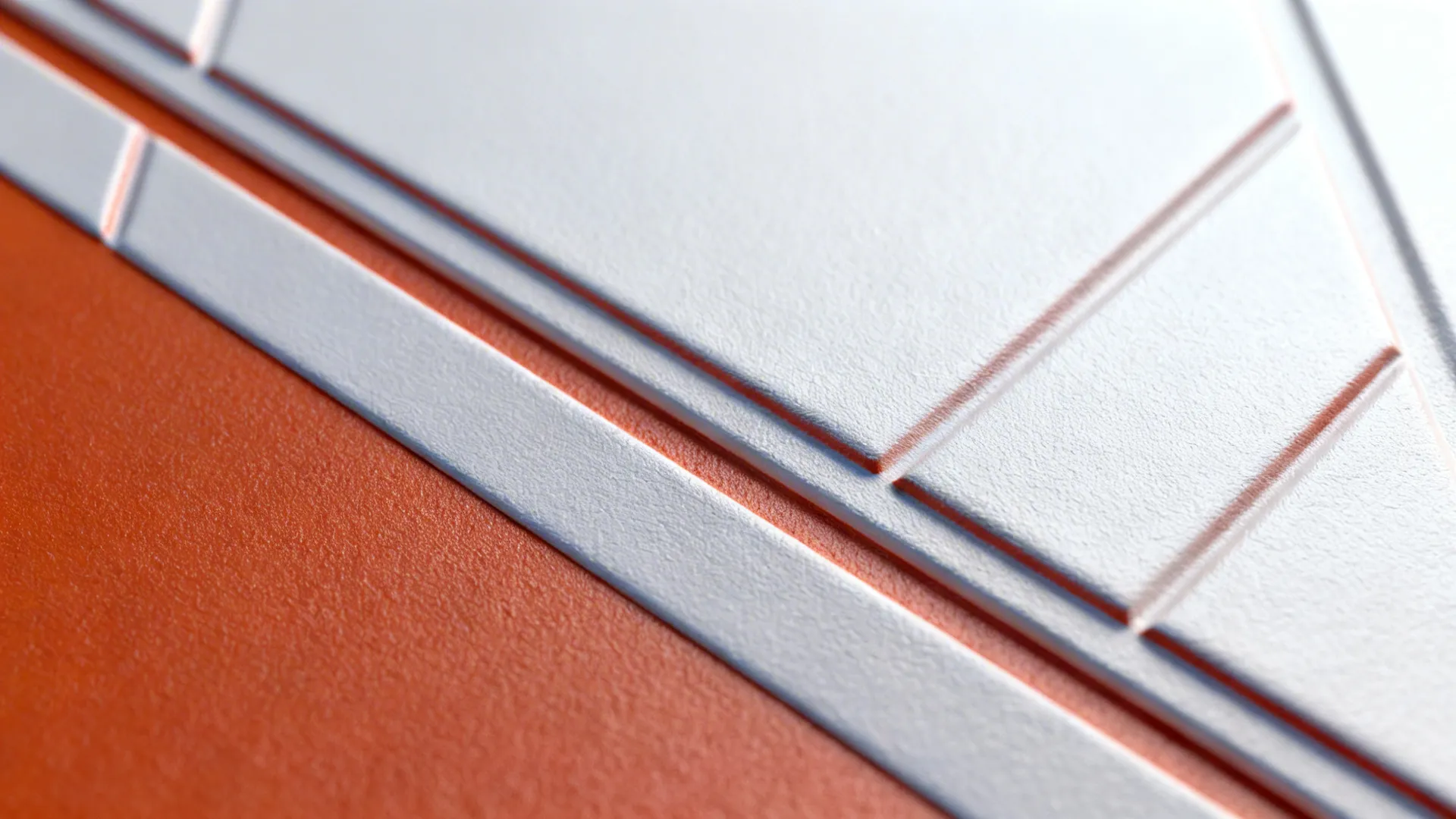 Macro of two-tone raised geometric wall showing crisp relief lines and soft shadows.