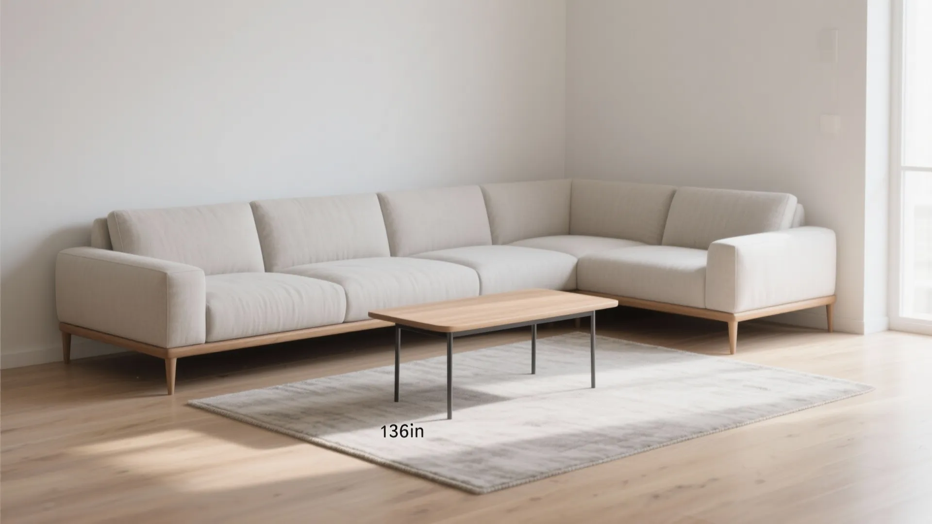 Beige sofa with wooden legs and coffee table on rug showing a large room floor