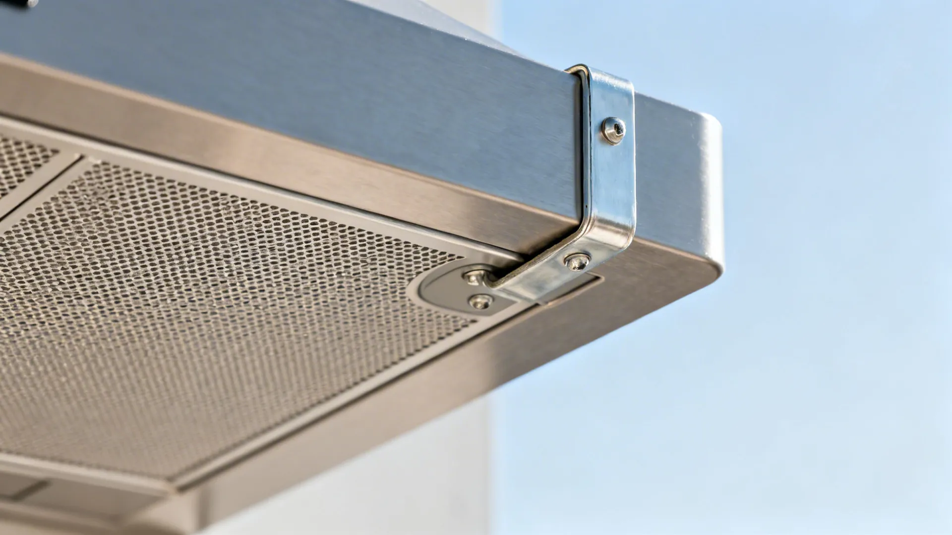 Macro of a high-quality rangehood baffle and sealed duct connection with corrosion-resistant finish.