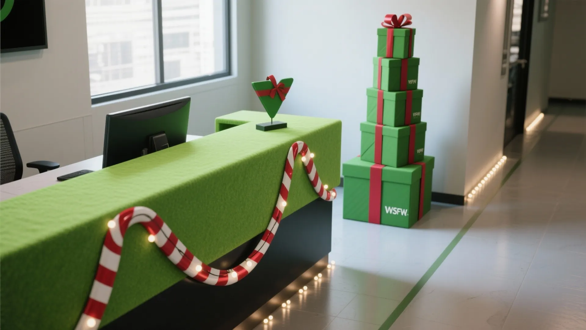 Modern reception desk with green fabric candy cane garland and tall stack of gift boxes