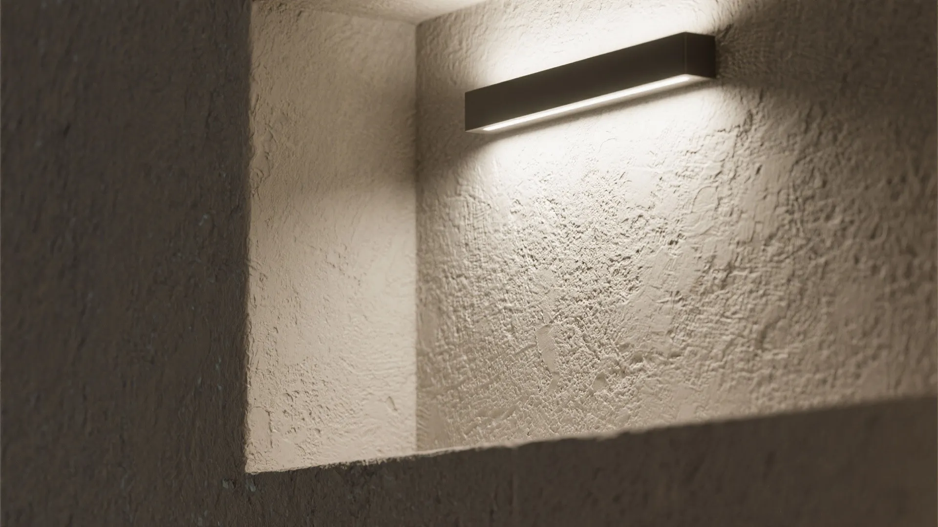 Modern black wall light fixture mounted inside a recessed niche illuminating a textured stone wall