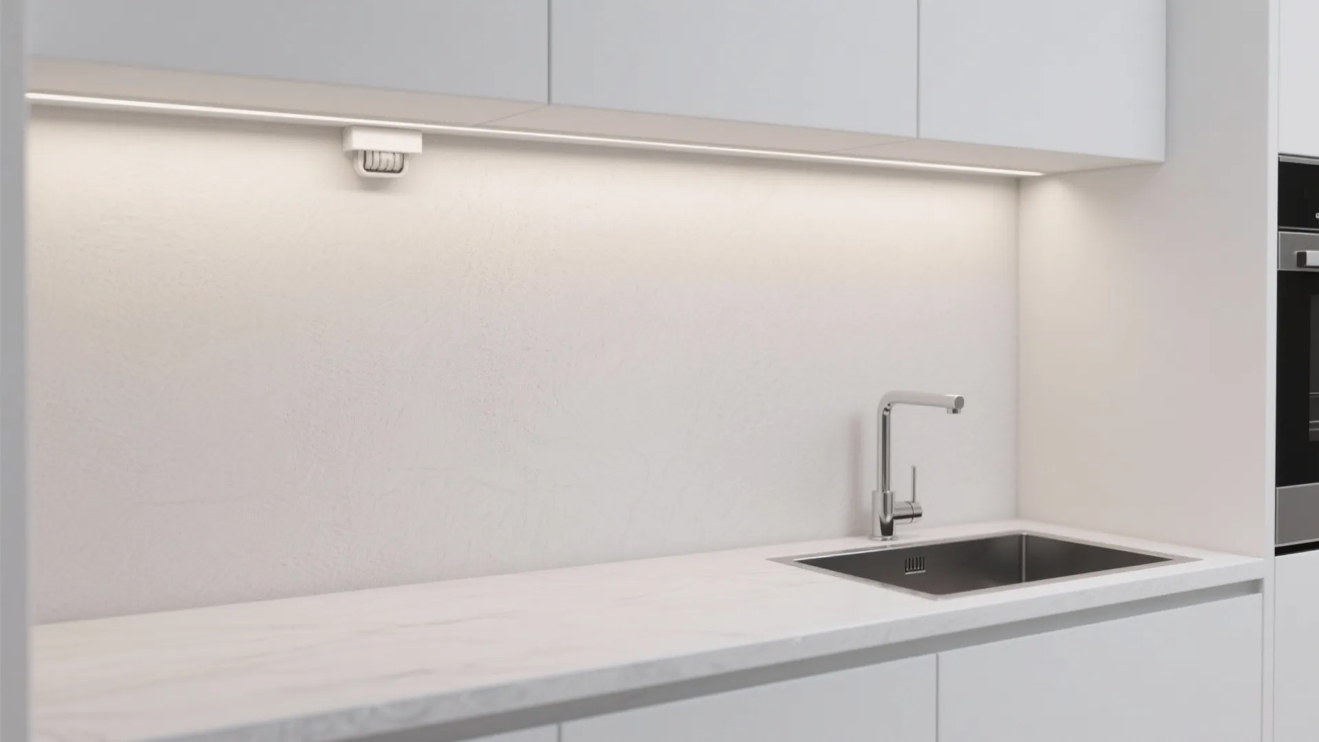 White minimalist kitchen cabinets with under cabinet light strip illuminating a marble countertop and sink