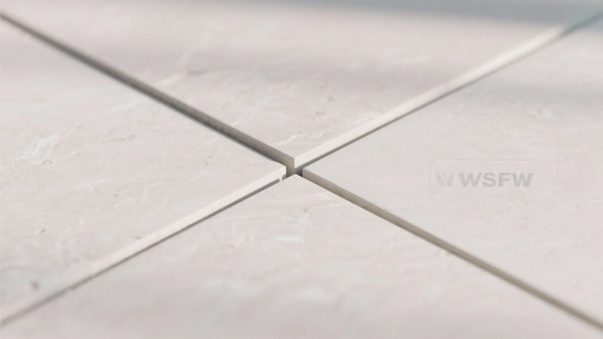 Close up view of four light grey floor tiles meeting at a clean straight cross joint