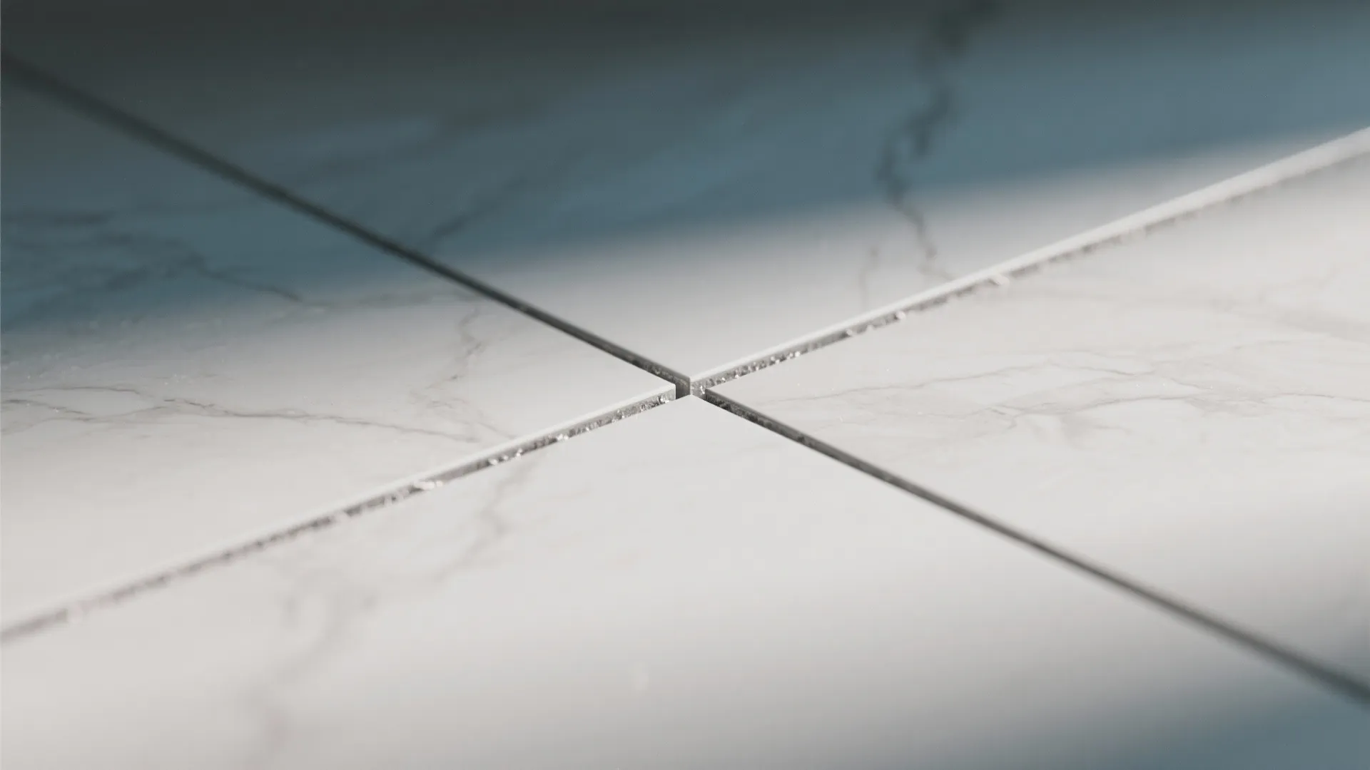Close-up of four marble floor tiles meeting at a clean joint with very thin grout